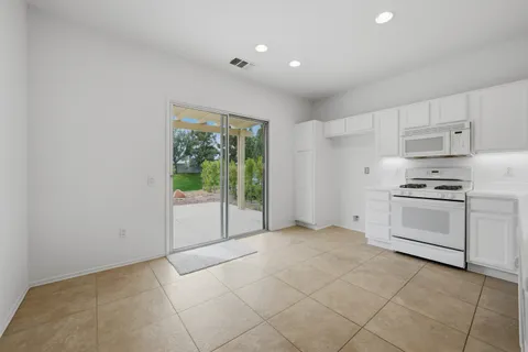 a kitchen with white cabinets and white appliances