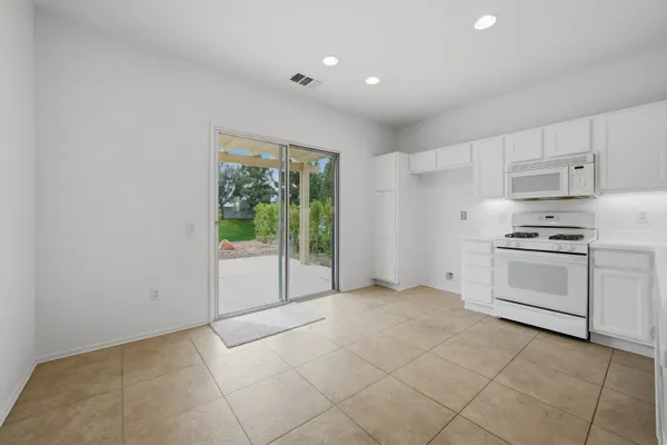 a kitchen with white cabinets and white appliances