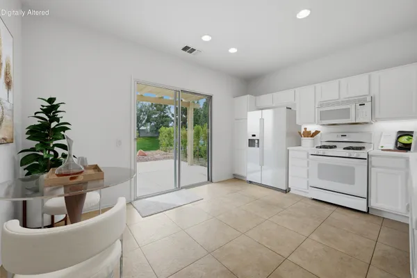 a kitchen with white cabinets and white appliances