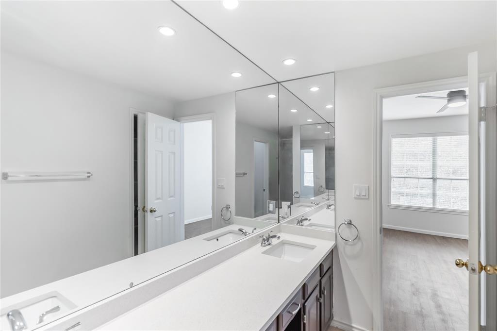 12680 Hillcrest Road, Unit 4101 Dallas, TX 75230 - Photo 29 of 37 Bathroom featuring a double vanity with integrated rectangular sinks, white countertops, and dark wood cabinetry