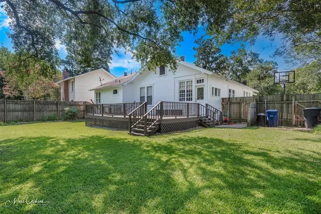 a view of a house with a big yard and large trees
