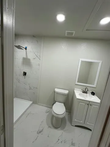 a bathroom with a toilet and a shower