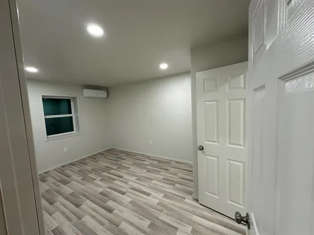 a view of empty room with wooden floor and window