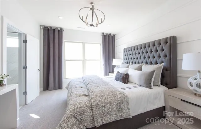 a bedroom with a large bed and a chandelier