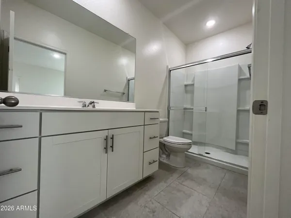a bathroom with a shower sink vanity and toilet