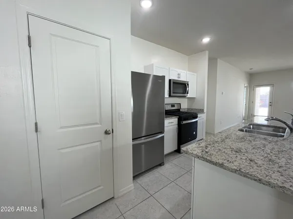 a kitchen with stainless steel appliances granite countertop a refrigerator and a sink