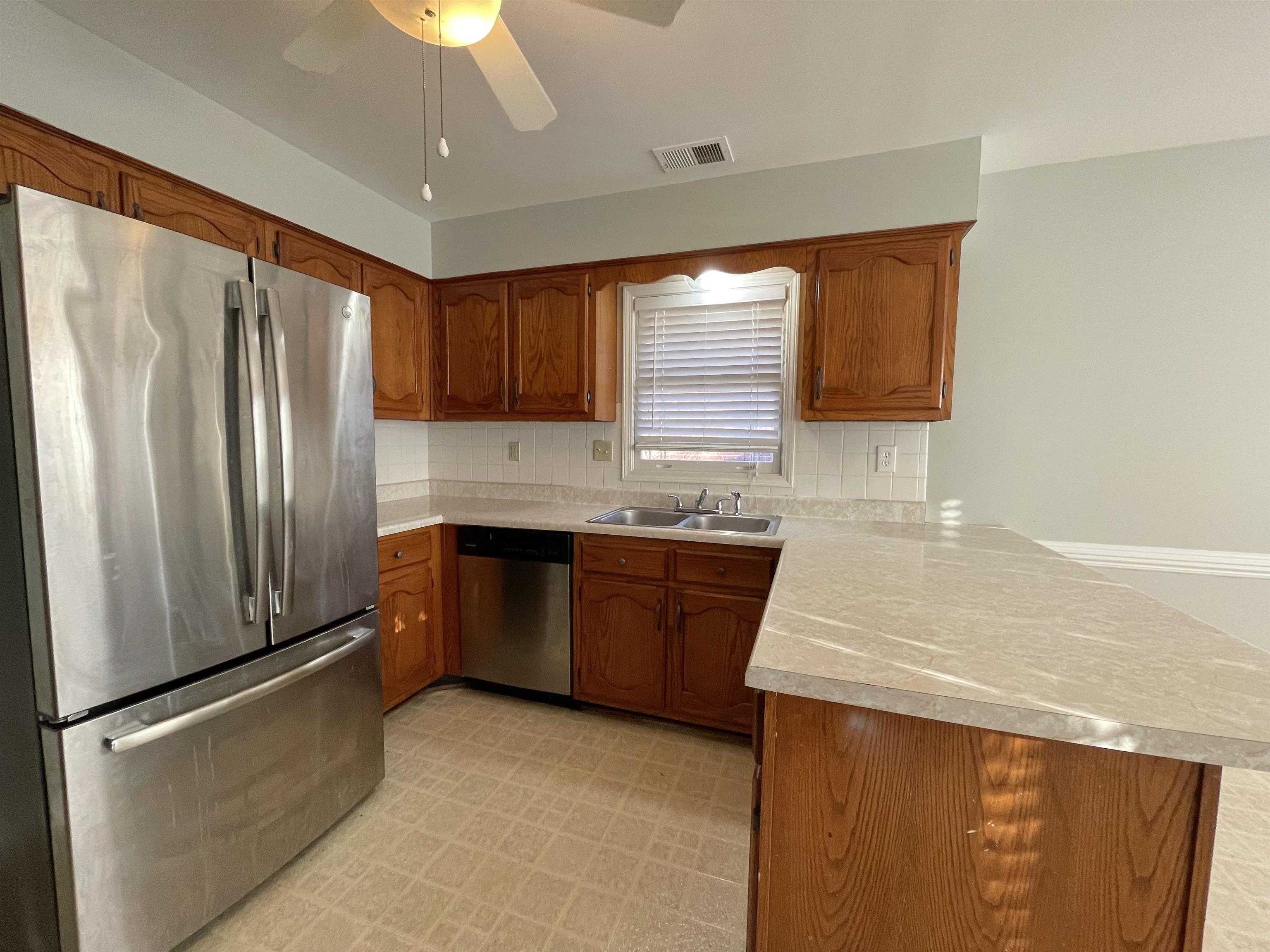 8859 Raspberry Lane Memphis, TN 38016 - Photo 2 of 16 a kitchen with granite countertop a refrigerator and a sink