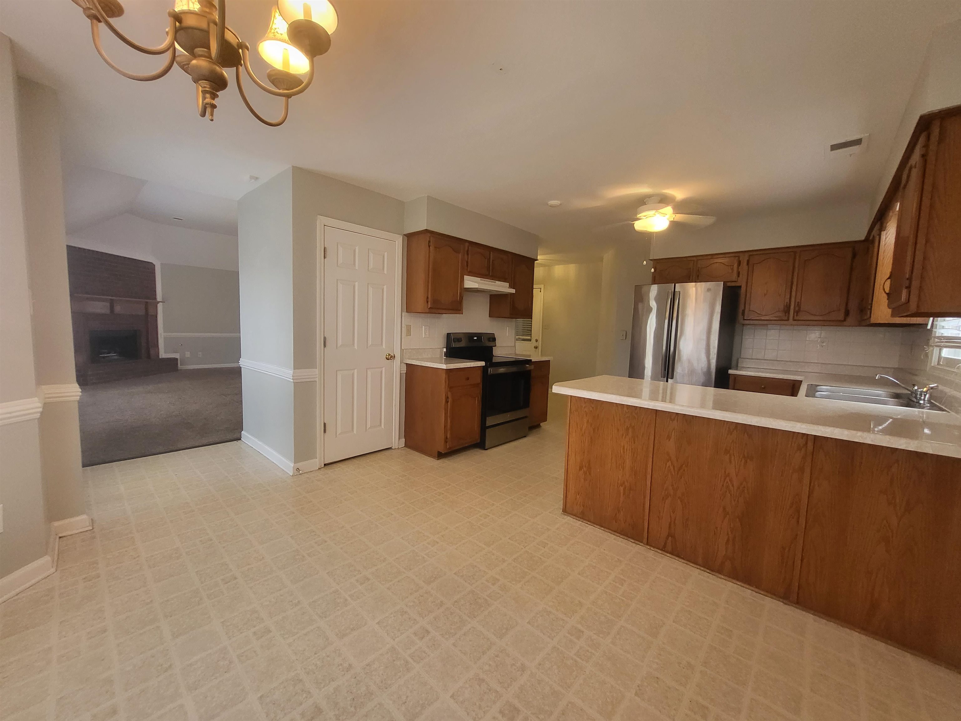 8859 Raspberry Lane Memphis, TN 38016 - Photo 3 of 16 a kitchen with stainless steel appliances granite countertop a refrigerator and a sink