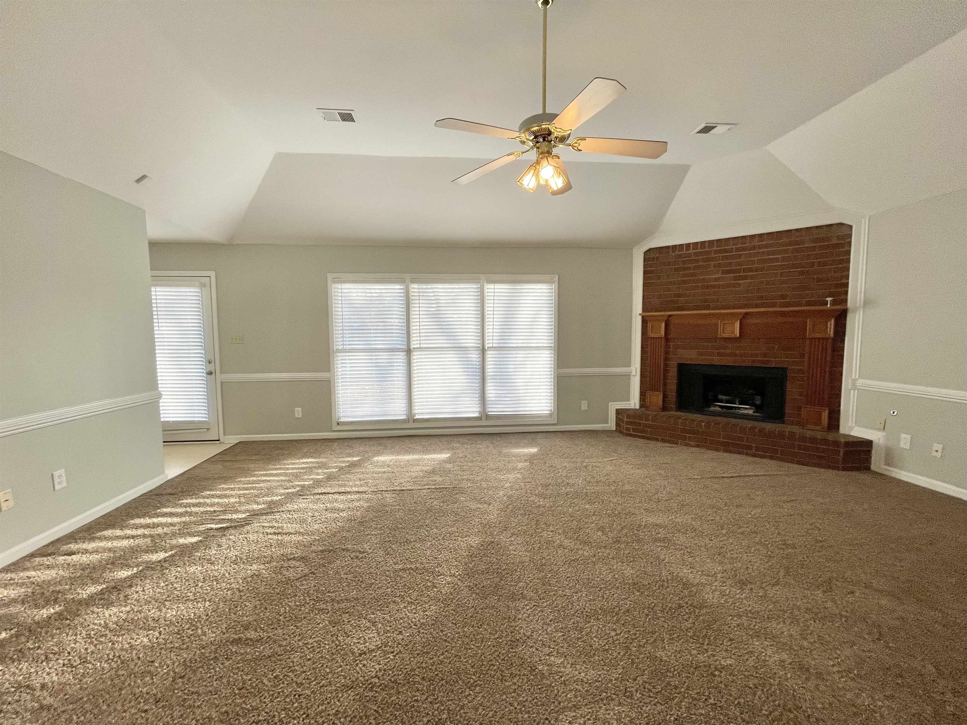 8859 Raspberry Lane Memphis, TN 38016 - Photo 6 of 16 an empty room with windows and fireplace