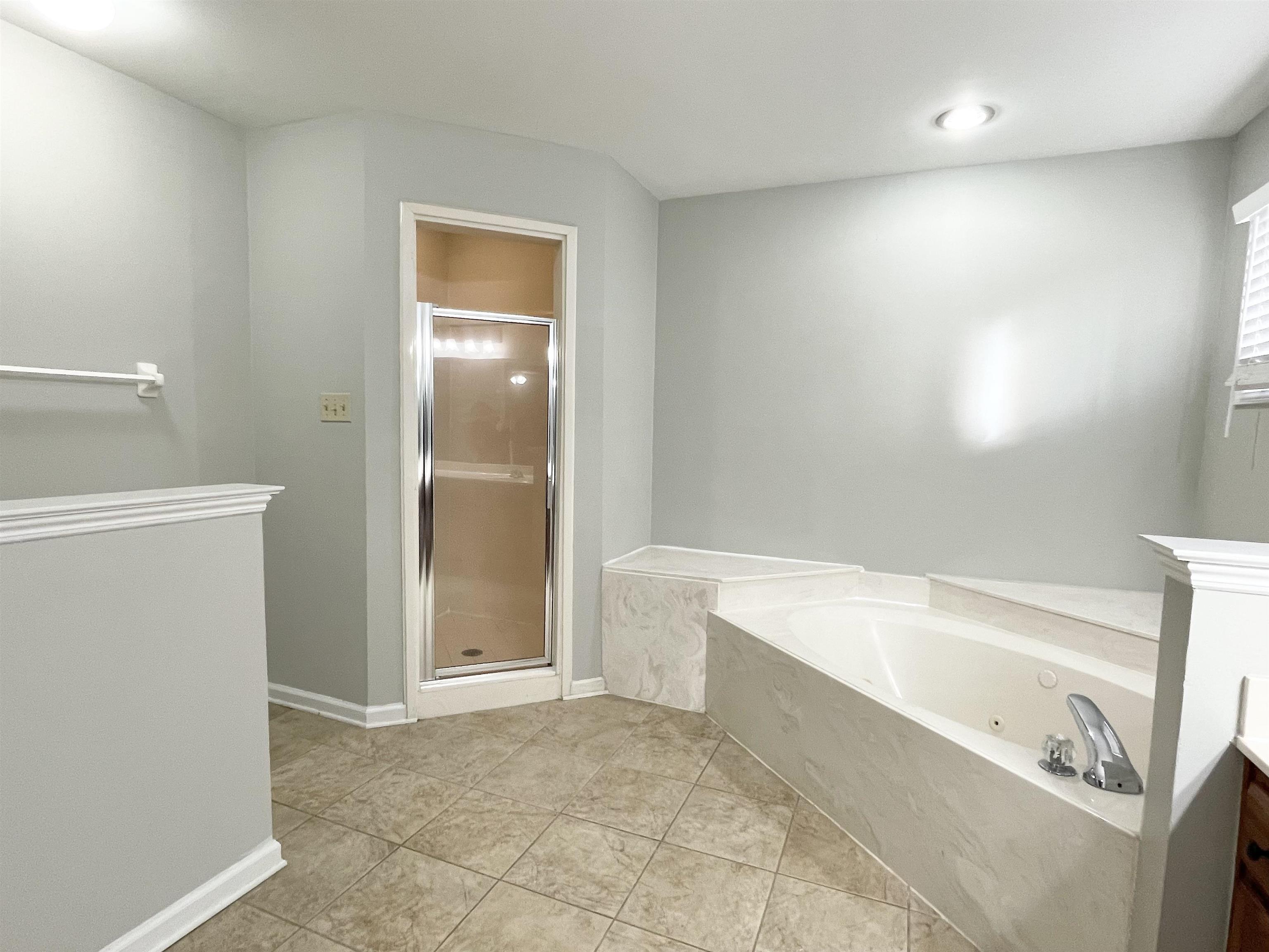 8859 Raspberry Lane Memphis, TN 38016 - Photo 9 of 16 a bathroom with a bathtub and a shower