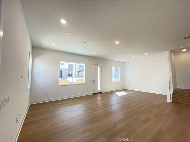 an empty room with wooden floor and window