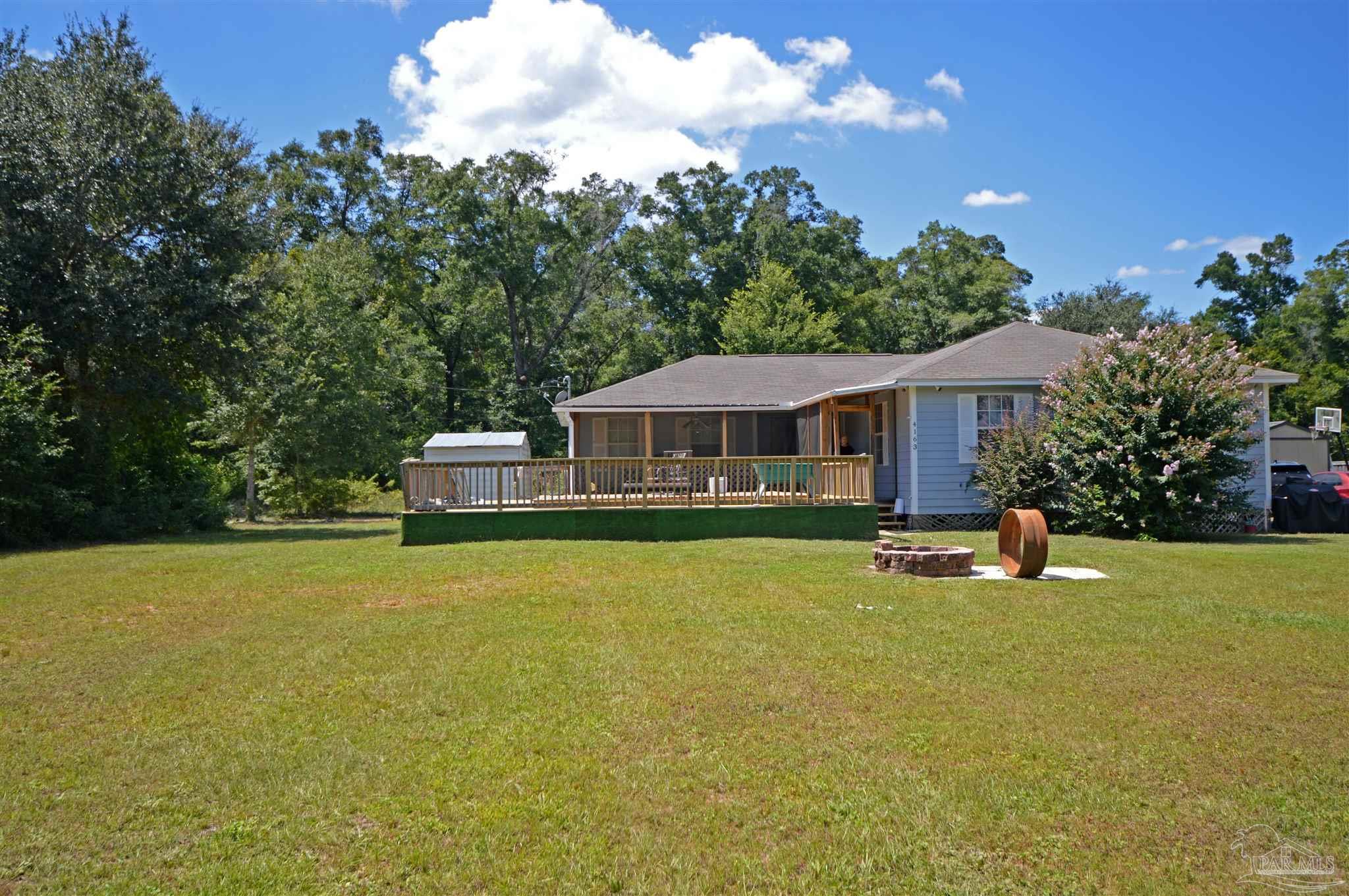 4163 Woodville Road Milton, FL 32583 - Photo 1 of 35 a front view of a house with swimming pool