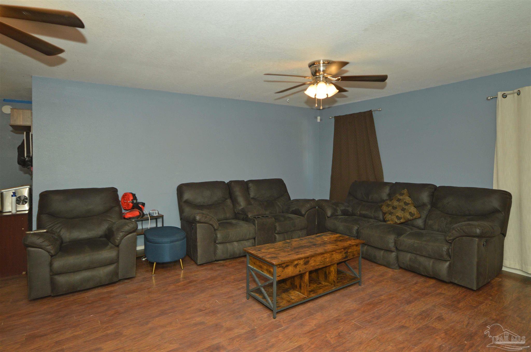 4163 Woodville Road Milton, FL 32583 - Photo 11 of 35 a living room with furniture and a chandelier