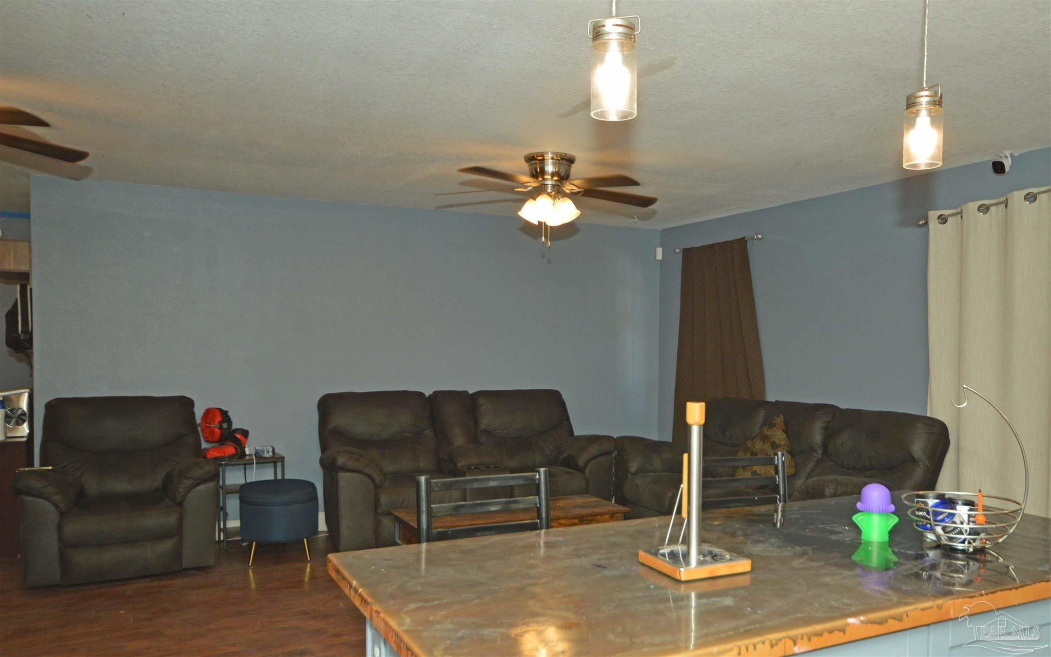 4163 Woodville Road Milton, FL 32583 - Photo 12 of 35 a living room with furniture and a chandelier