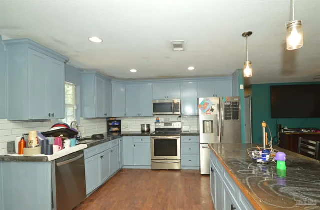 a kitchen that has a lot of cabinets a sink and appliances in it