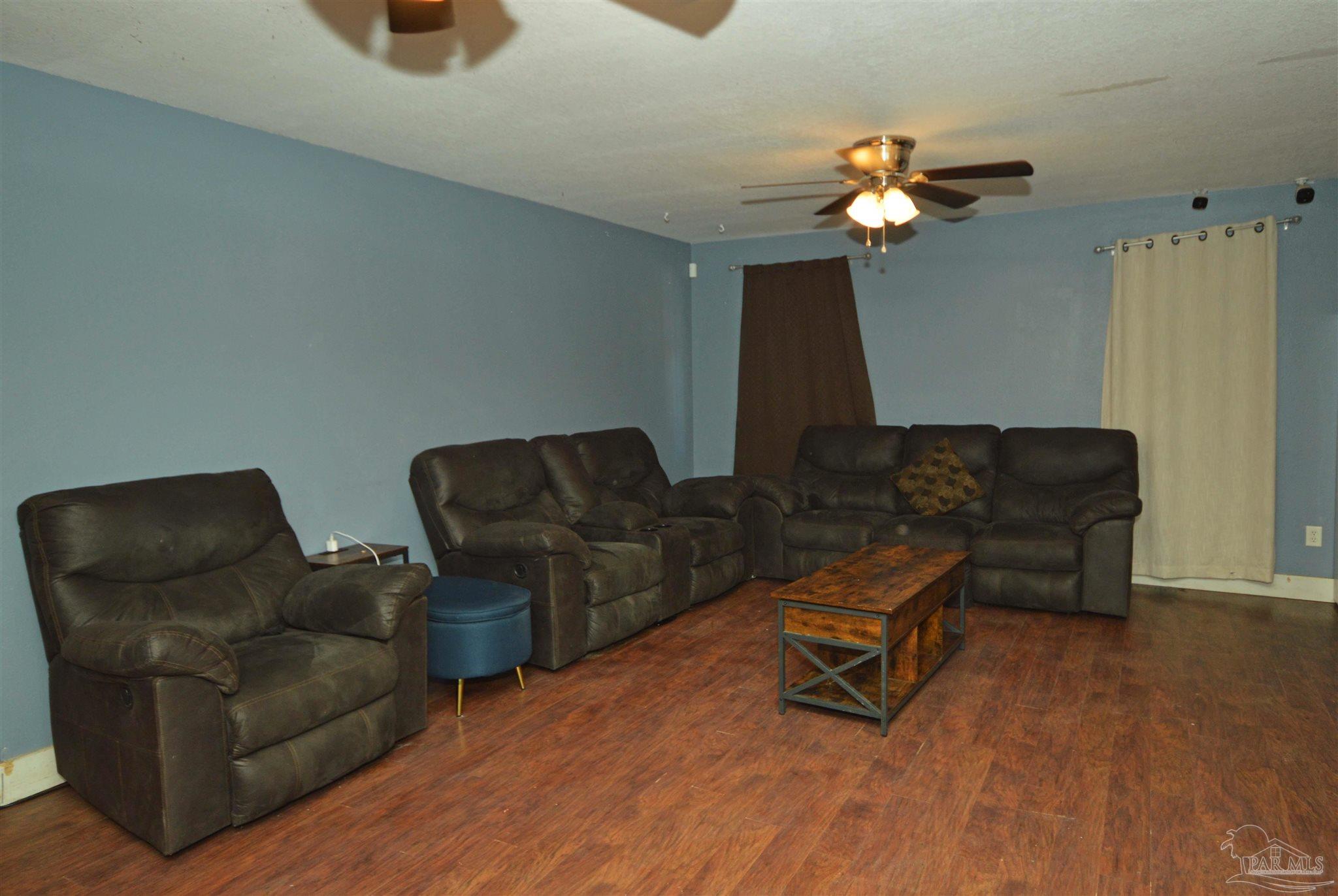 4163 Woodville Road Milton, FL 32583 - Photo 17 of 35 a living room with furniture and a chandelier