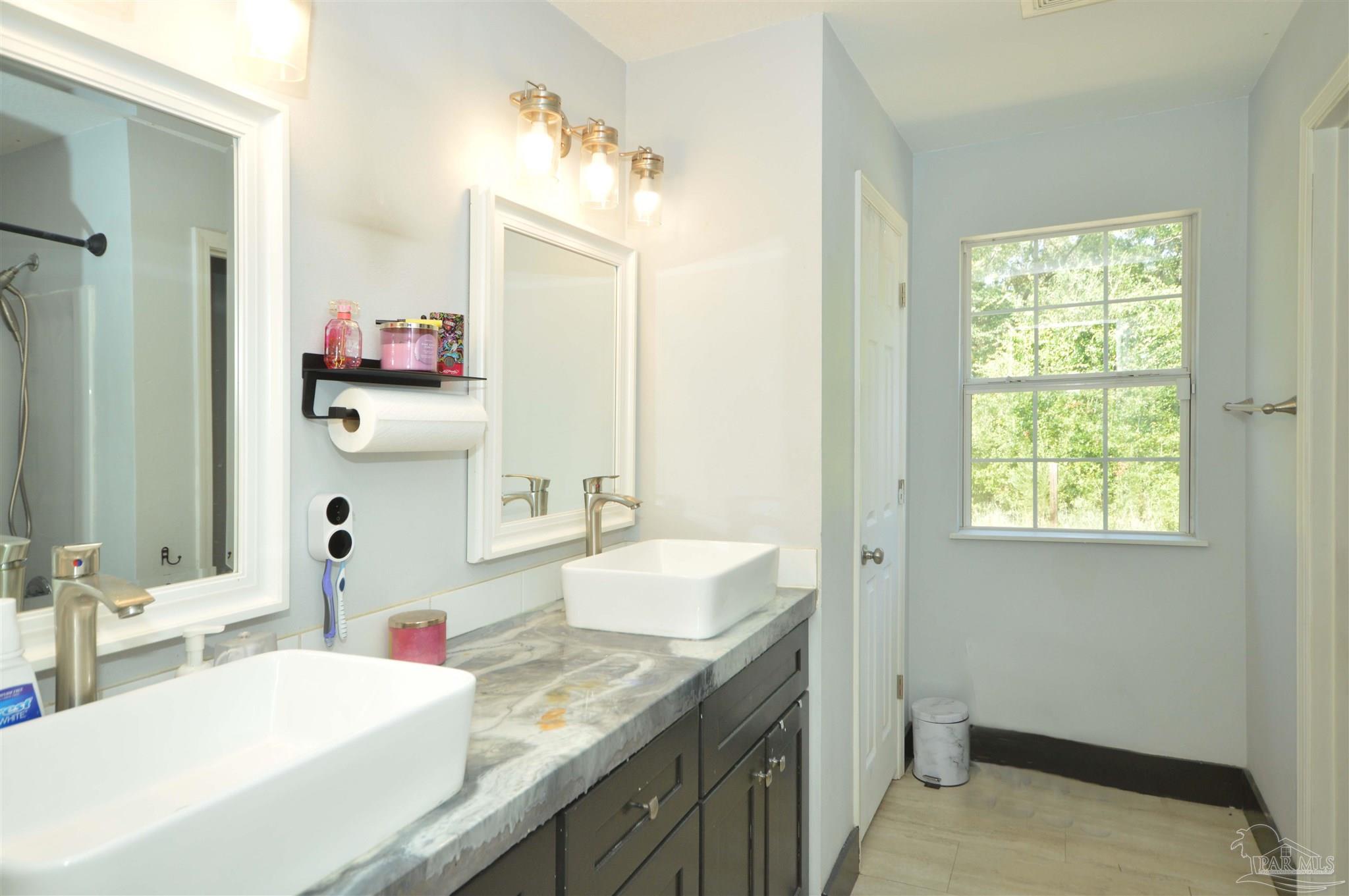 4163 Woodville Road Milton, FL 32583 - Photo 20 of 35 a bathroom with a sink and a mirror