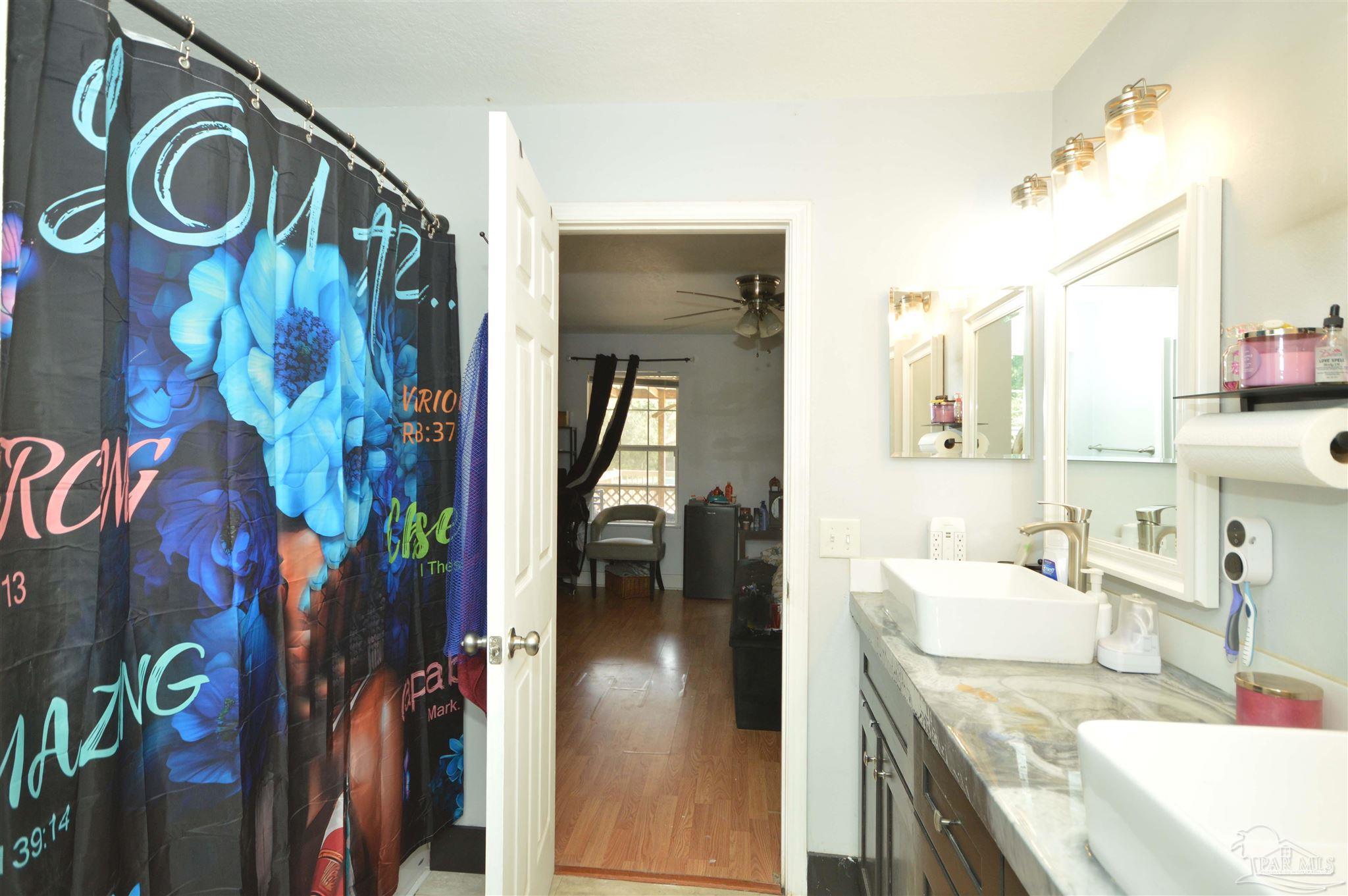 4163 Woodville Road Milton, FL 32583 - Photo 22 of 35 a en suite bathroom with a sink and a mirror