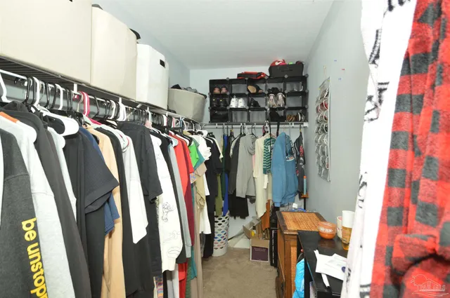 a view of walk in closet with clothes
