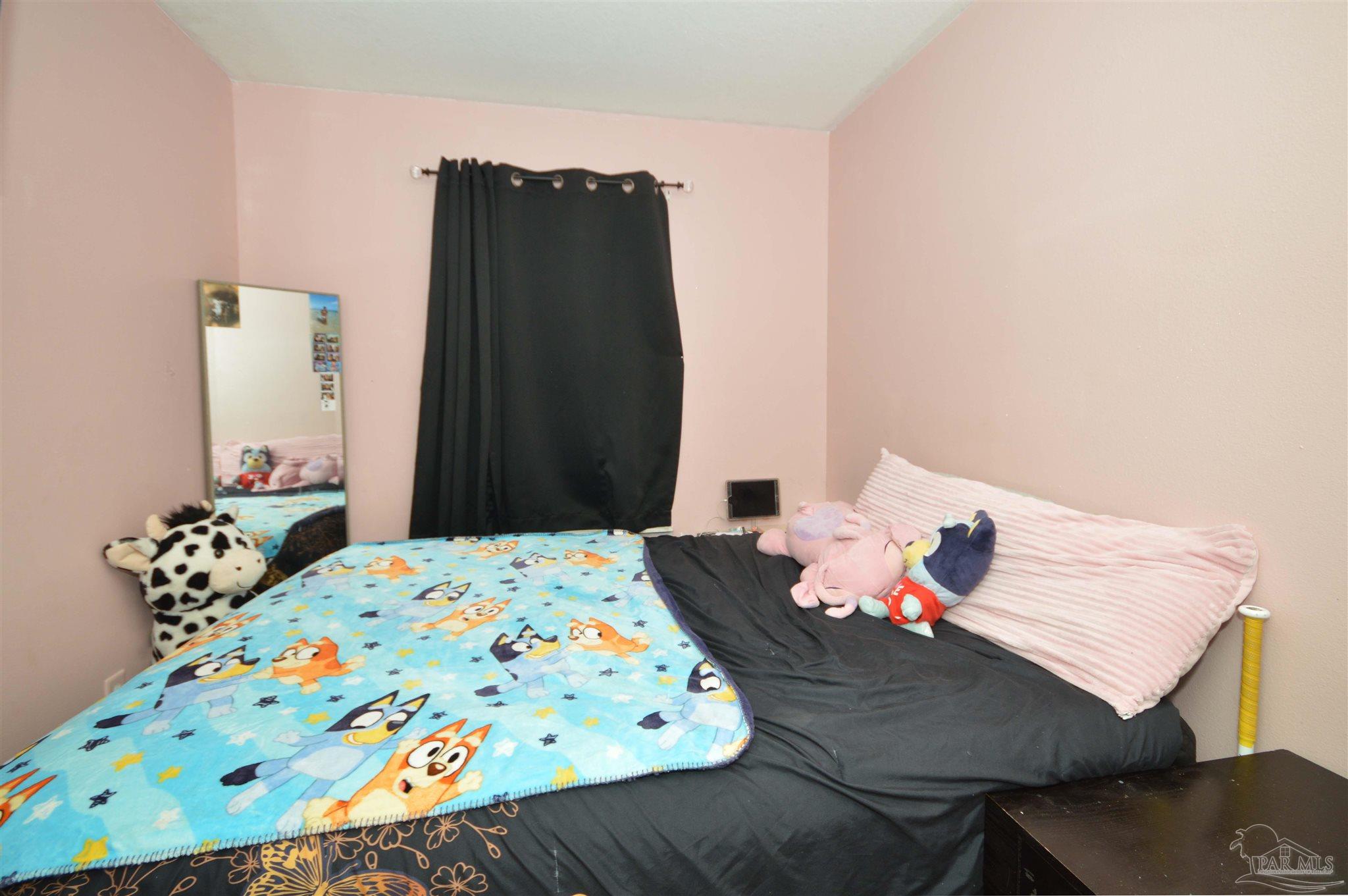 4163 Woodville Road Milton, FL 32583 - Photo 24 of 35 a bedroom with a bed and a table