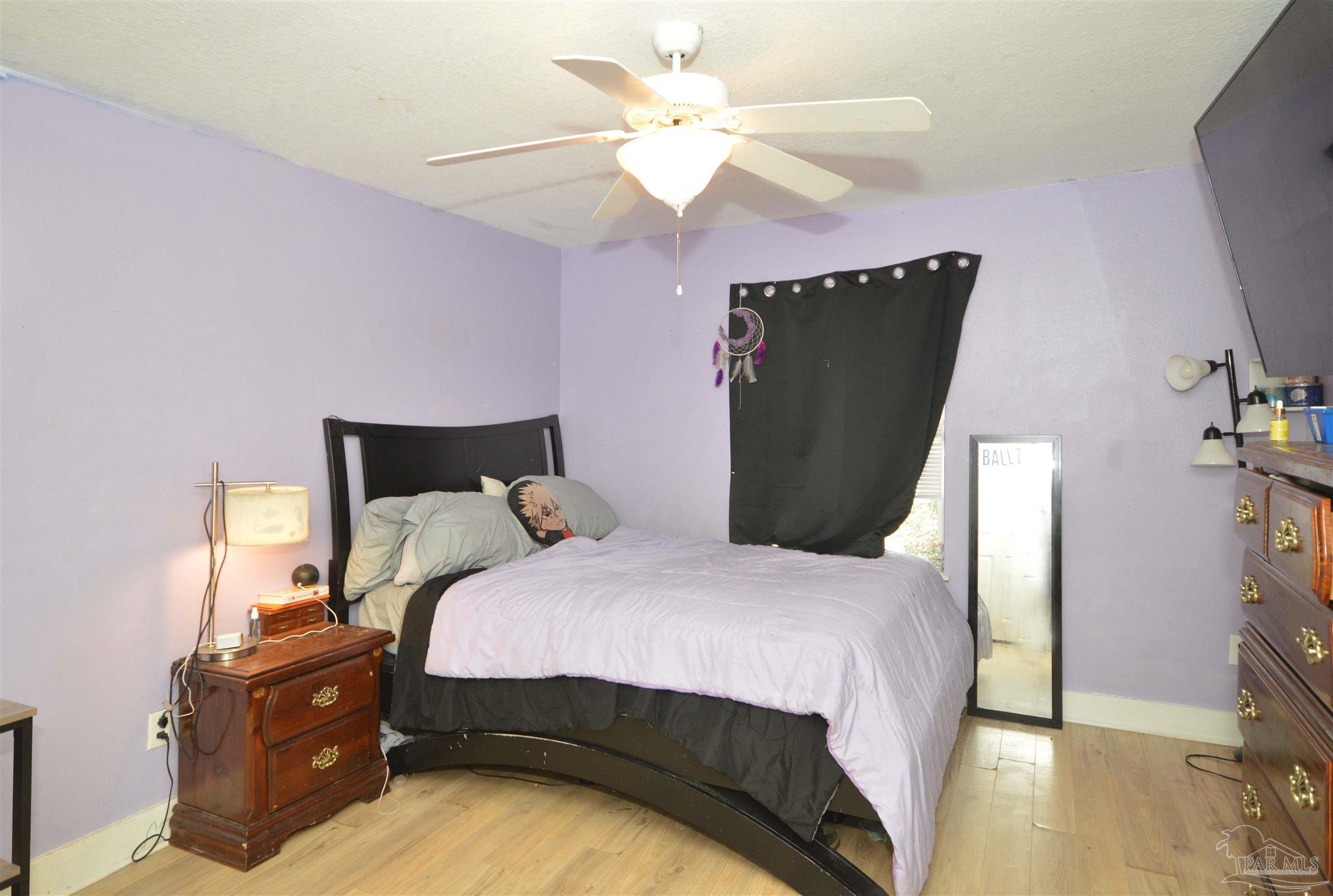 4163 Woodville Road Milton, FL 32583 - Photo 26 of 35 a bedroom with a bed and a ceiling fan