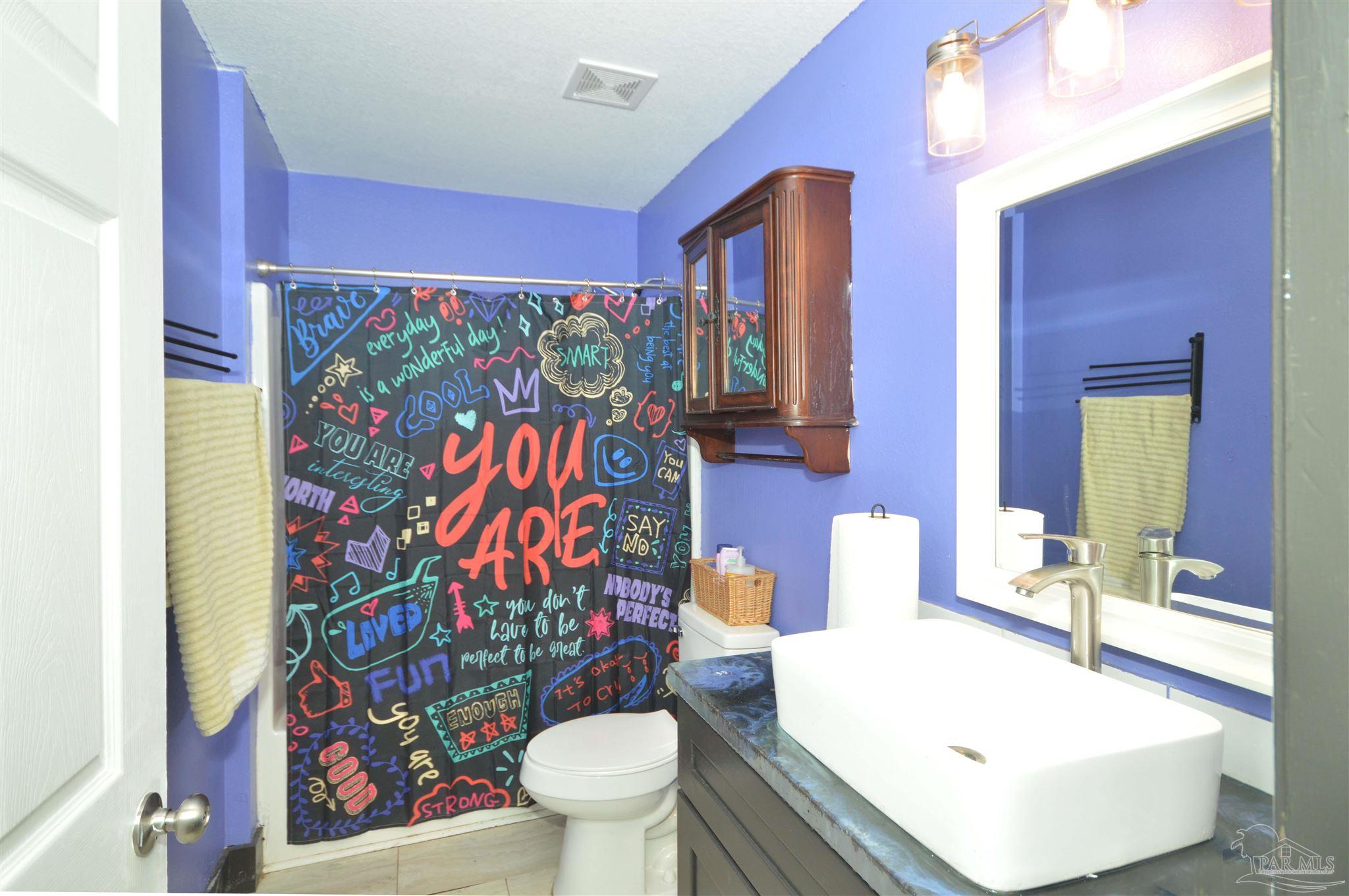 4163 Woodville Road Milton, FL 32583 - Photo 27 of 35 a bathroom with a sink mirror vanity and toilet