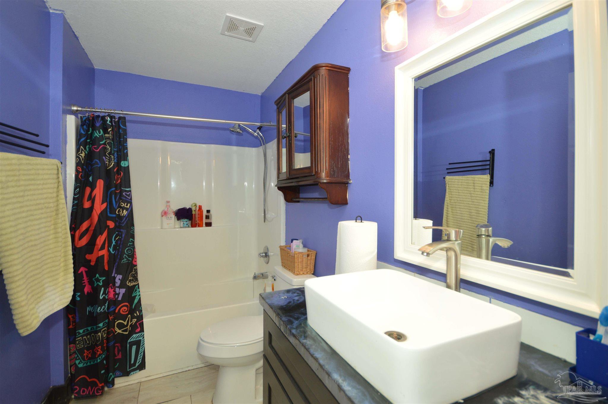 4163 Woodville Road Milton, FL 32583 - Photo 28 of 35 a bathroom with a sink toilet and shower