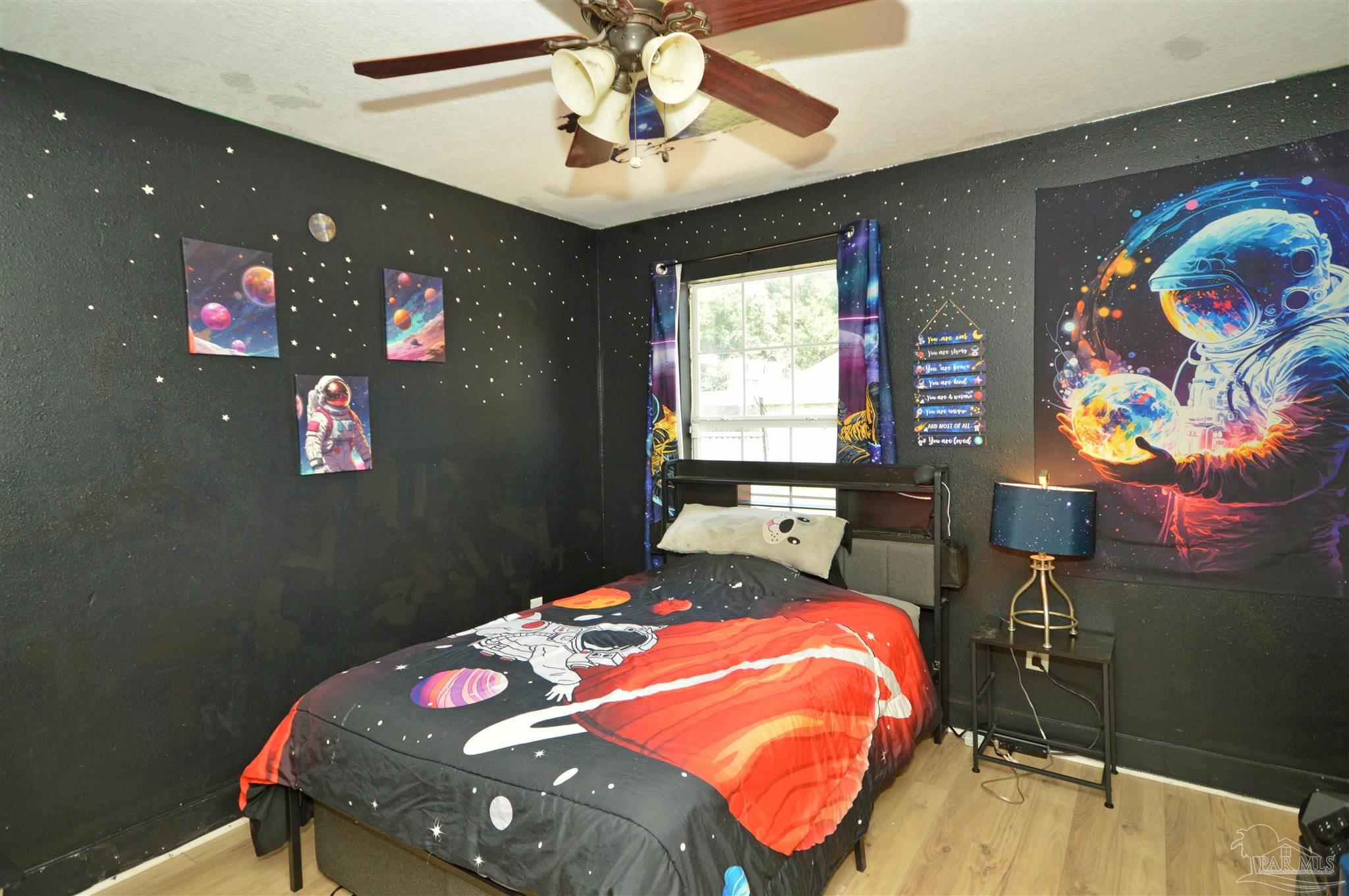 4163 Woodville Road Milton, FL 32583 - Photo 29 of 35 a bedroom with a bed and a chandelier