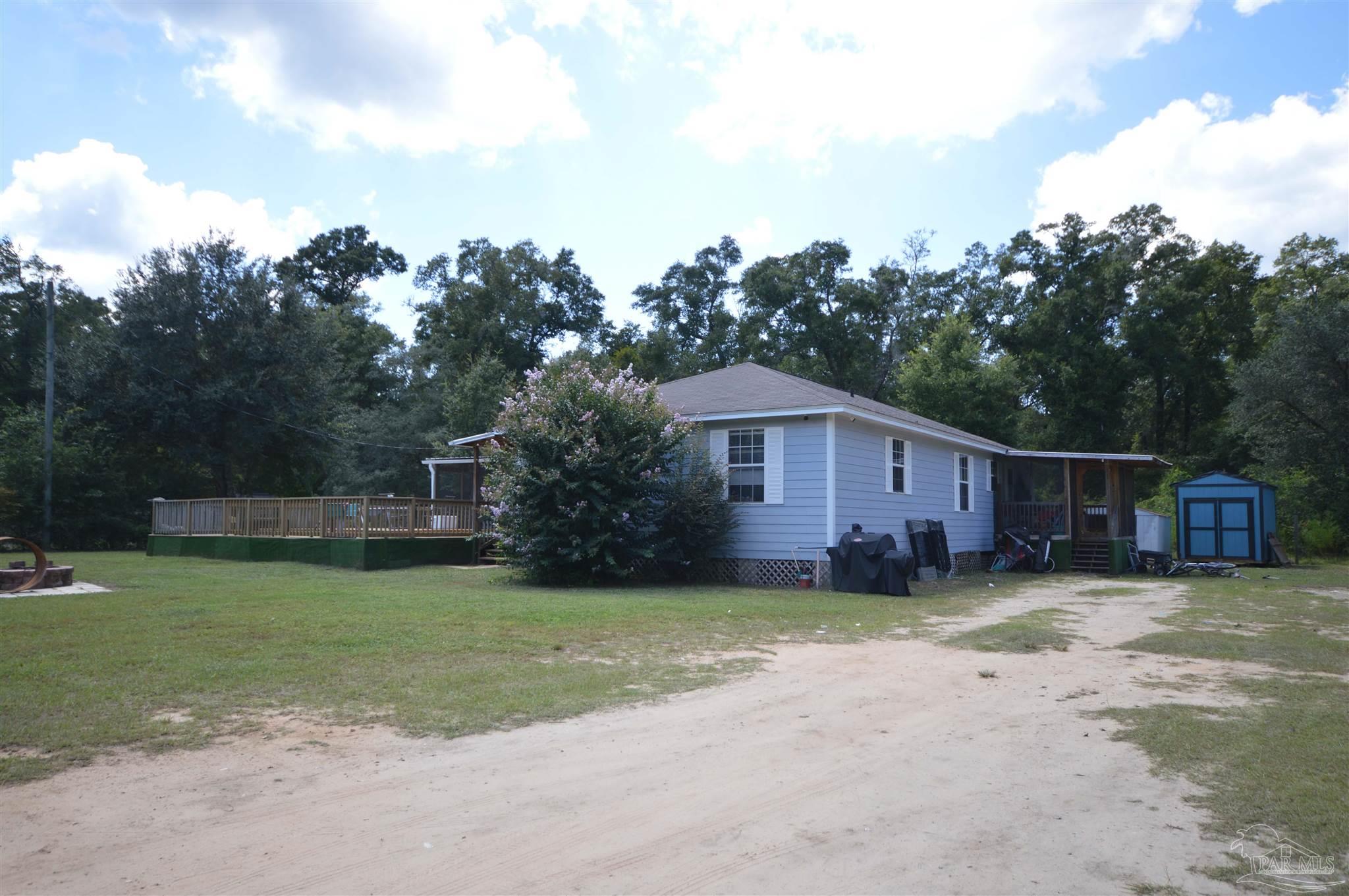 4163 Woodville Road Milton, FL 32583 - Photo 33 of 35 a view of a house with a yard and sitting area