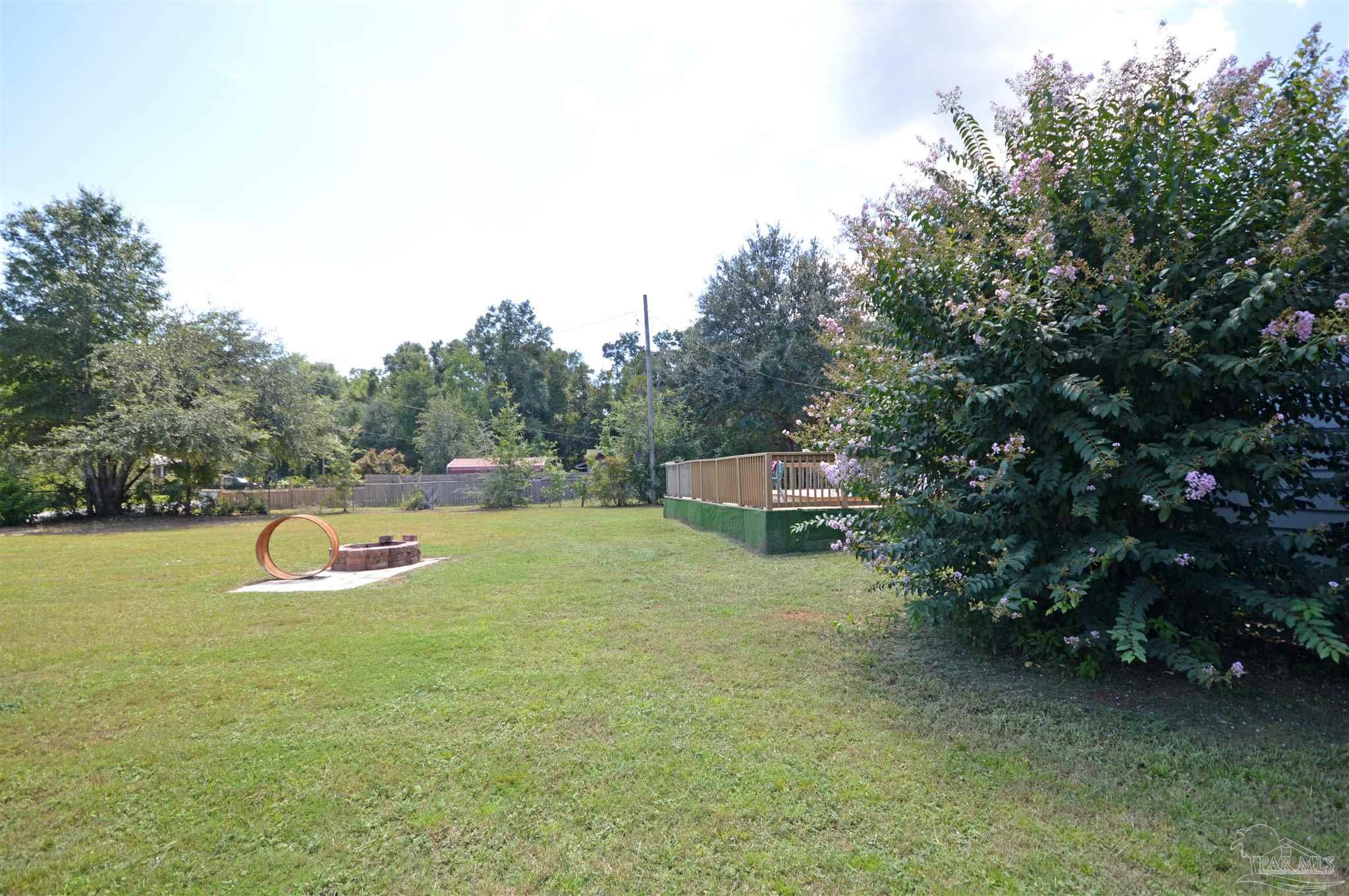 4163 Woodville Road Milton, FL 32583 - Photo 5 of 35 a backyard of a house with swimming pool and trees