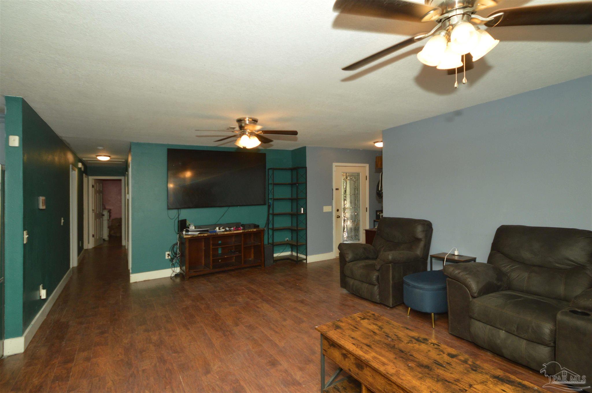 4163 Woodville Road Milton, FL 32583 - Photo 10 of 35 a living room with furniture and a flat screen tv