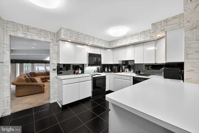 a kitchen with a sink a stove and white cabinets
