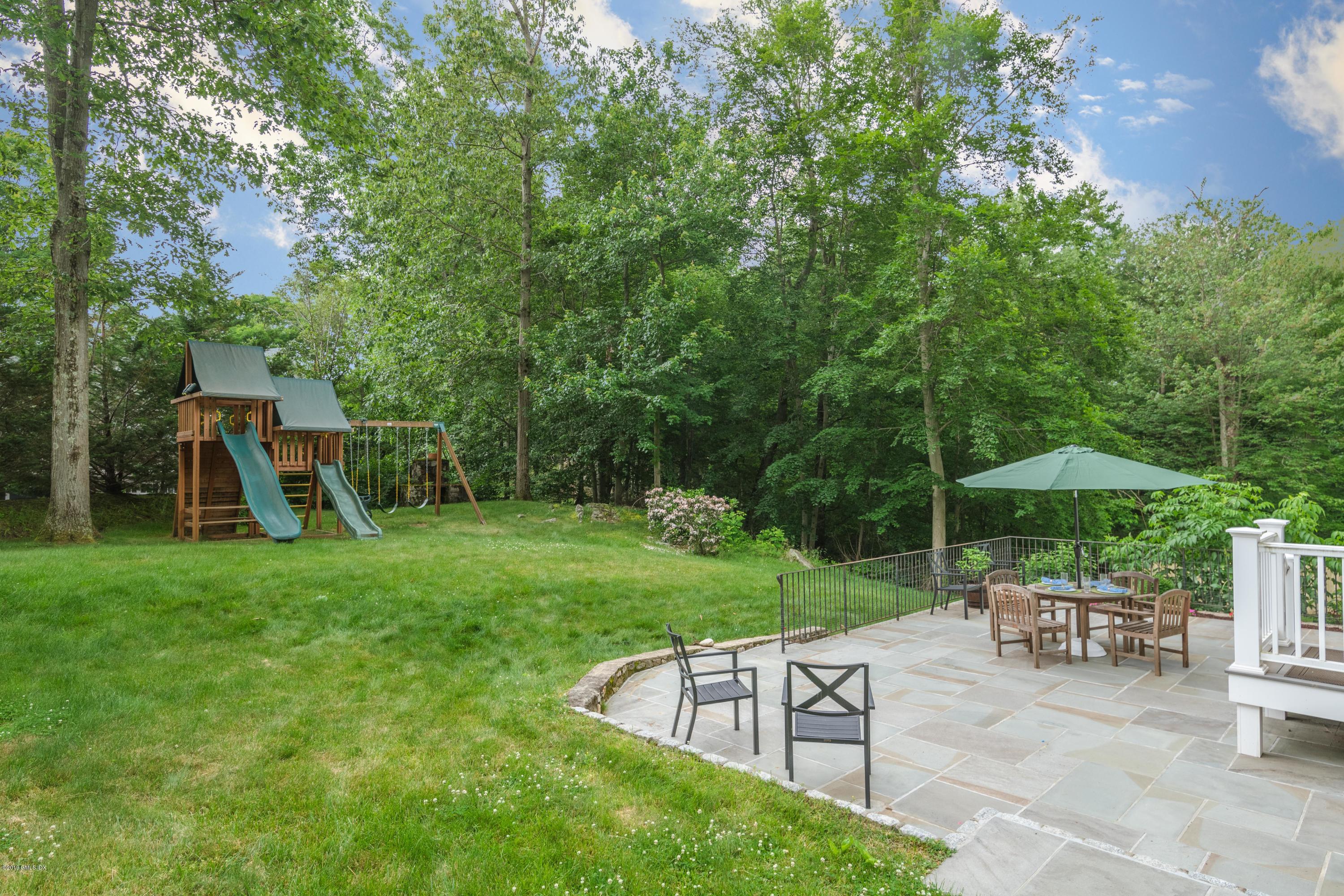 94 Cognewaugh Road Cos Cob, CT 06807 - Photo 3 of 25 a view of a chair and table under an umbrella