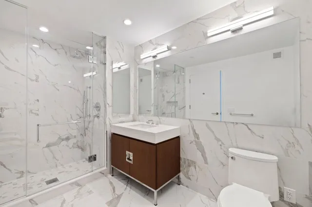 a bathroom with a sink a toilet and shower