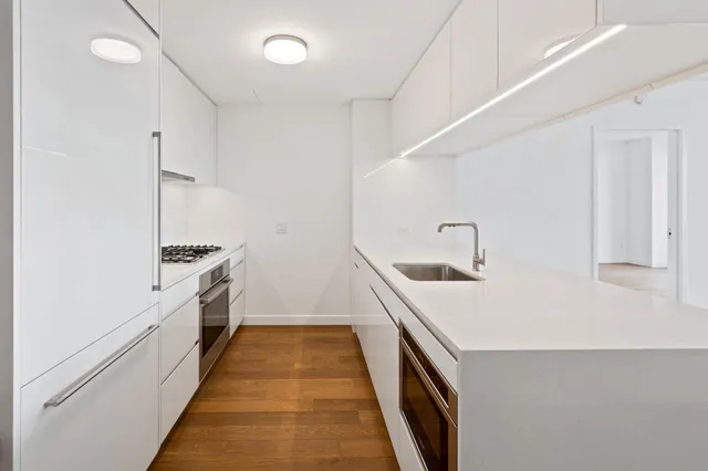 a kitchen with a sink and wooden floor