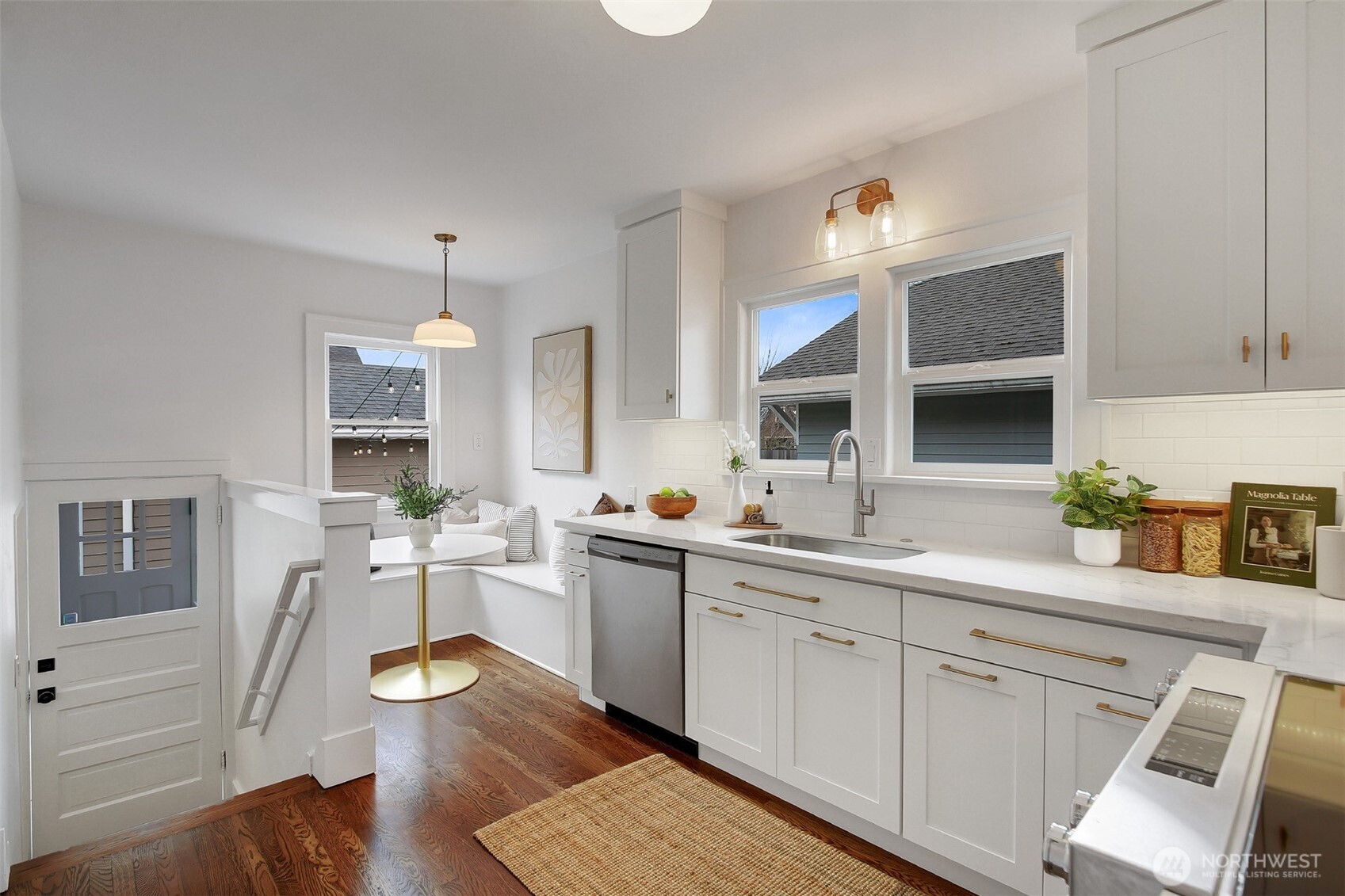 720 North 46th Street Seattle, WA 98103 - Photo 18 of 32 a kitchen with a sink dishwasher stove and white cabinets with wooden floor
