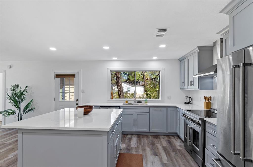 1400 East Shady Grove Road Irving, TX 75060 - Photo 10 of 39 a kitchen with a sink a counter top space stainless steel appliances and windows