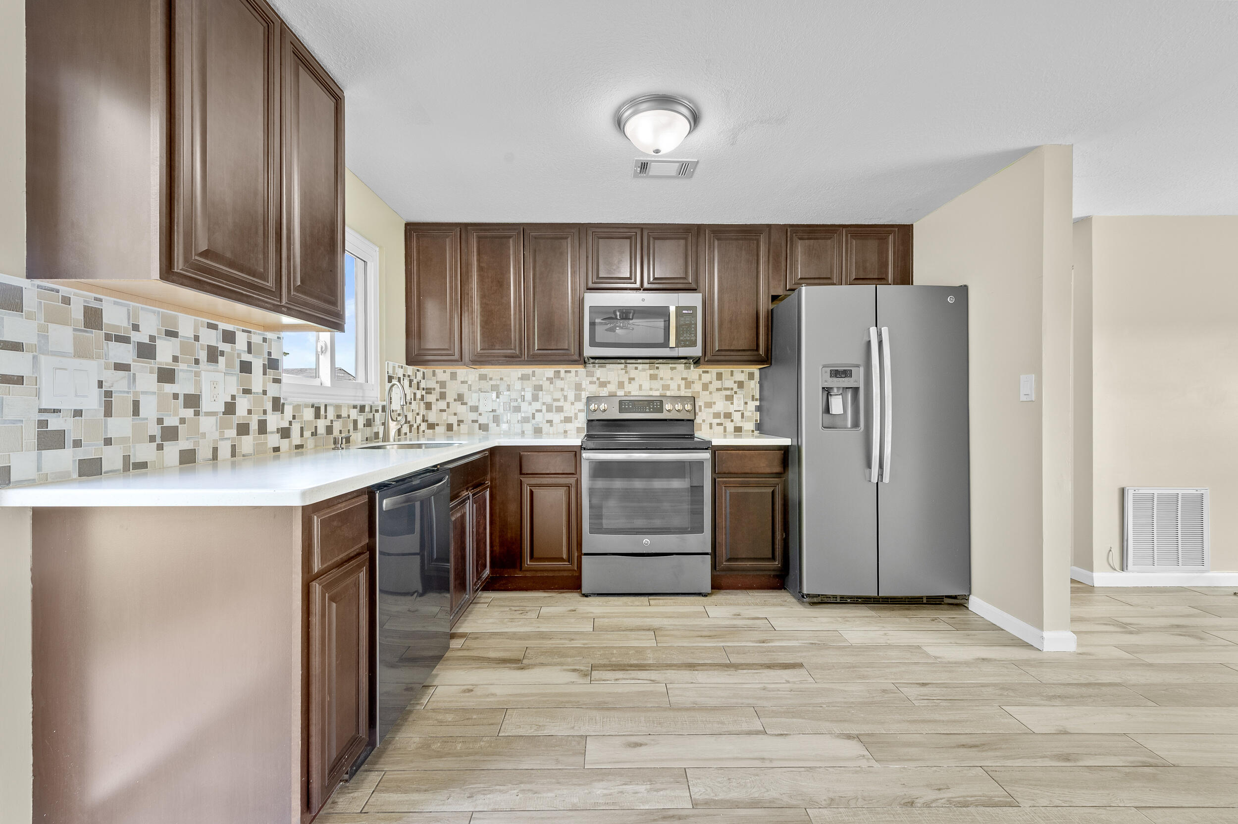 1357 Ryan Lane Royal Palm Beach, FL 33411 - Photo 3 of 23 a kitchen with stainless steel appliances granite countertop a refrigerator stove and sink