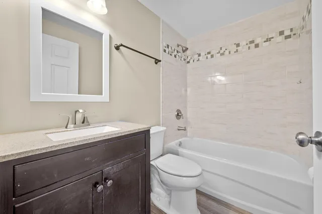 a bathroom with a granite countertop sink a toilet and shower