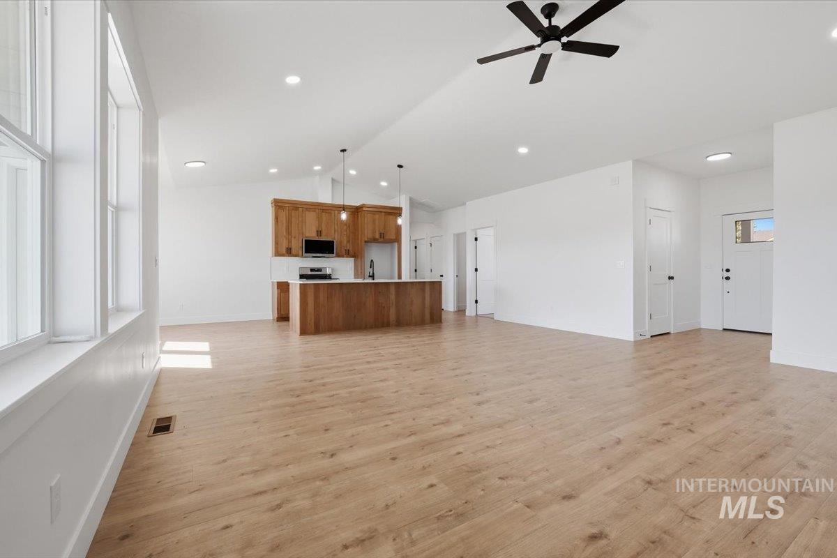 2175 Austin Way Fruitland, ID 83619 - Photo 8 of 30 Unfurnished living room featuring ceiling fan, light wood finished floors, and lofted ceiling