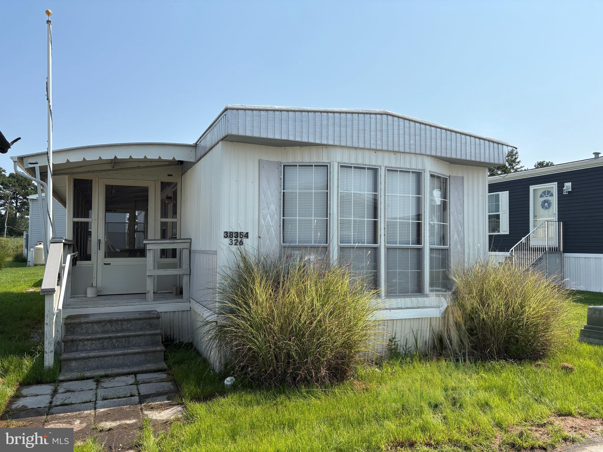 38354 Squirrel Road, Unit 19312 Ocean View, DE 19970 - Photo 1 of 39 a view of a house with potted plants and a fountain