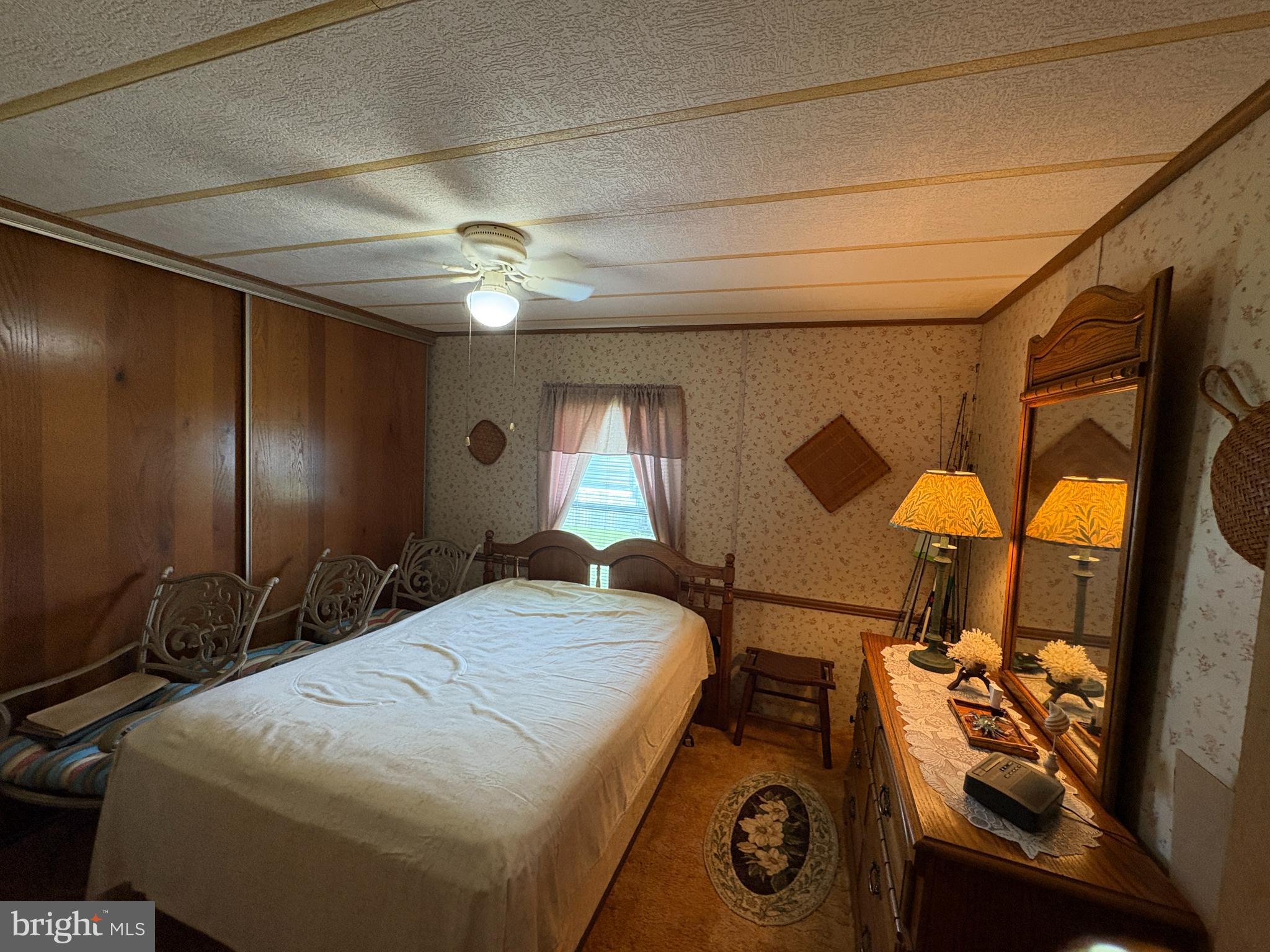 38354 Squirrel Road, Unit 19312 Ocean View, DE 19970 - Photo 32 of 39 a bedroom with a bed and a chandelier