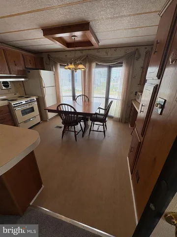 a dining room with furniture and a floor to ceiling window