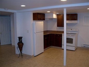 a kitchen with a refrigerator and a television