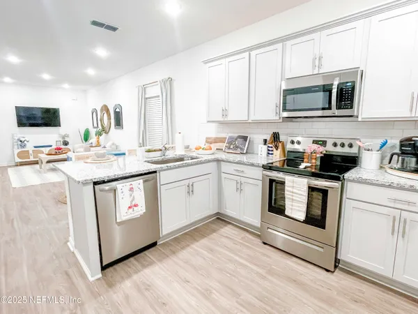 a kitchen with stainless steel appliances granite countertop a stove a sink and a microwave