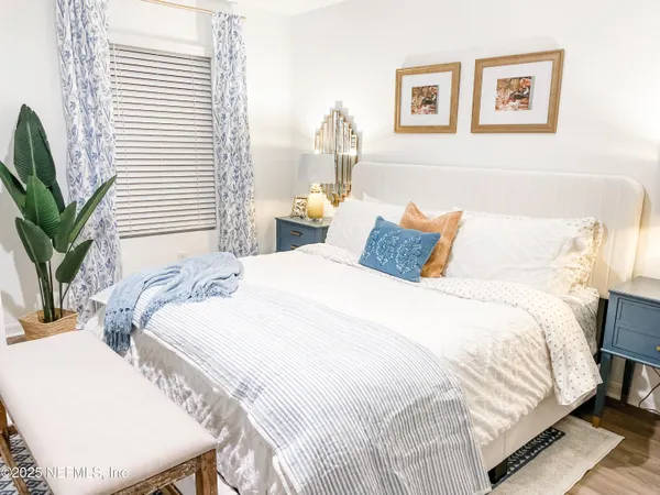 a bedroom with bed and a potted plant