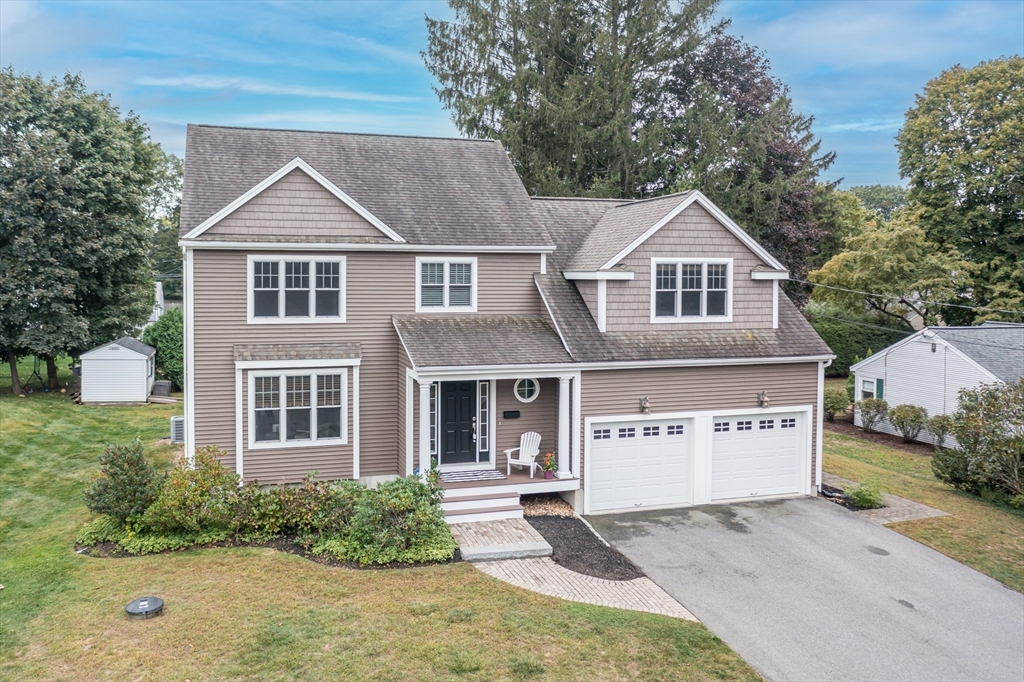 a view of a white house with large windows and a small yard