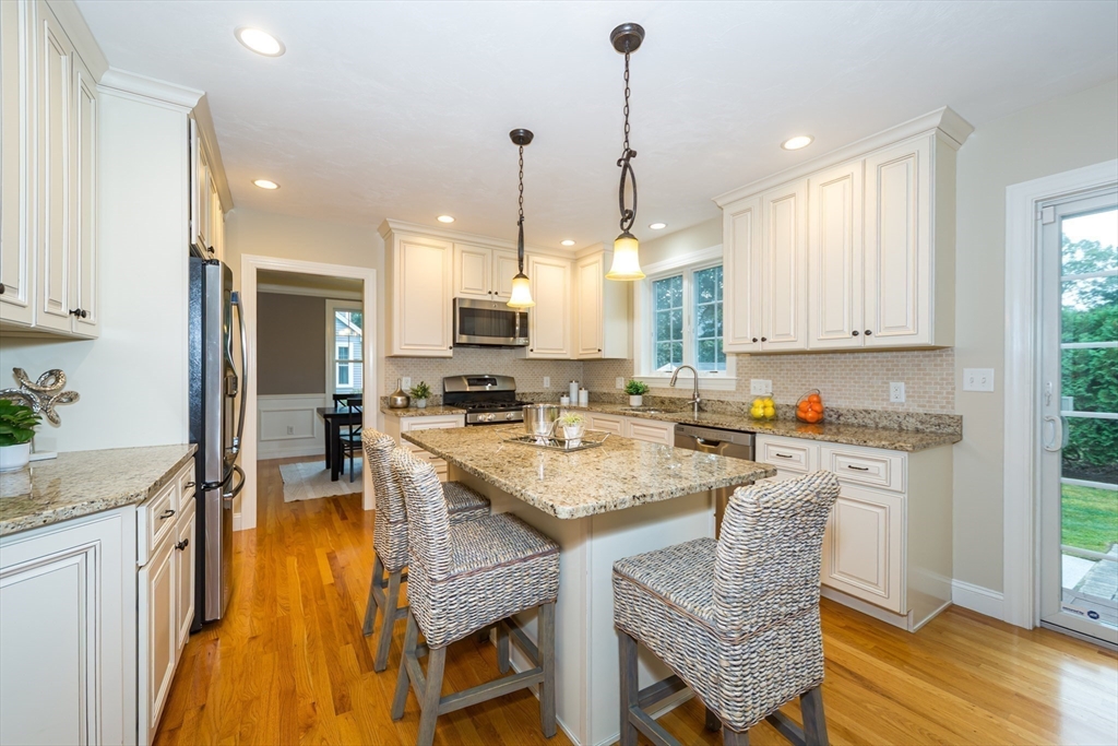 9 Flynn Street Natick, MA 01760 - Photo 11 of 36 a kitchen with stainless steel appliances granite countertop a stove a sink refrigerator and a wooden cabinets