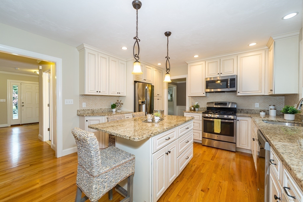 9 Flynn Street Natick, MA 01760 - Photo 12 of 36 a kitchen with stainless steel appliances granite countertop a stove oven and a white cabinets