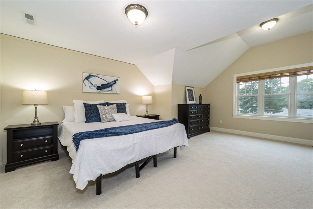 9 Flynn Street Natick, MA 01760 - Photo 18 of 36 a spacious bedroom with a bed and a lamp